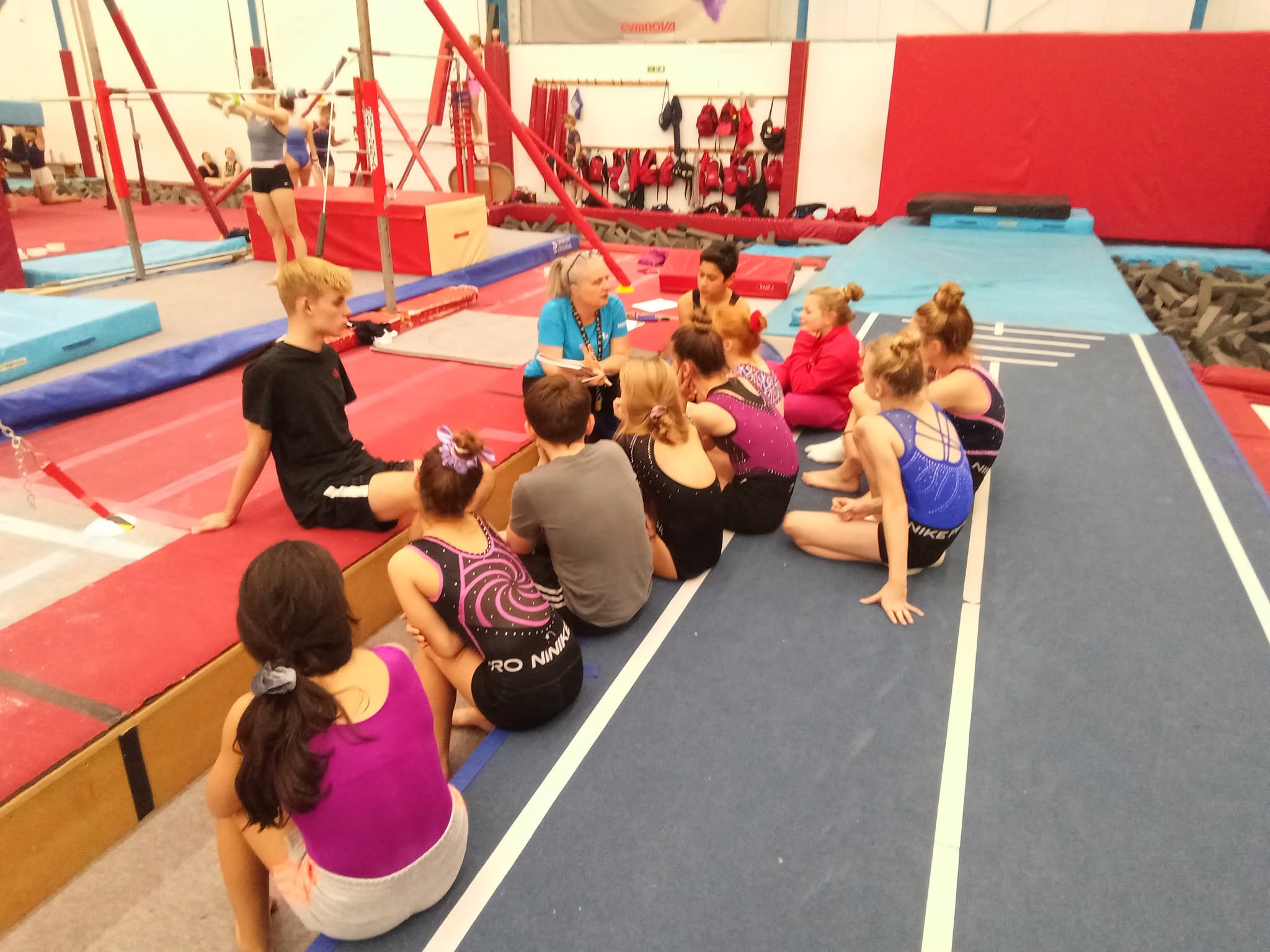 A BGC coach supporting a young gymnast in training