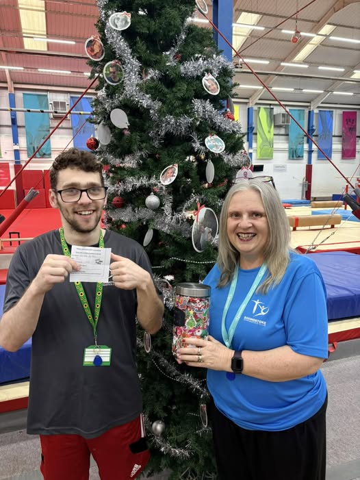 A BGC adult gymnast being presented with their safeguarding certificate in the gym